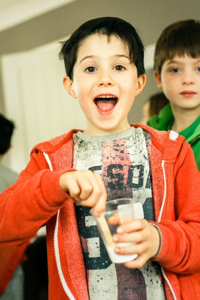 Boy mixing slime at science birthday party